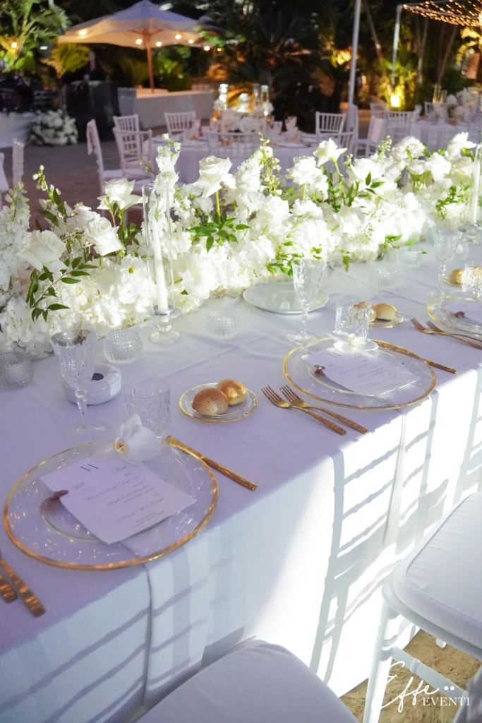 Mise en place total white su tavolo imperiale con milioni di luci scintillanti, perfetta per un matrimonio elegante.