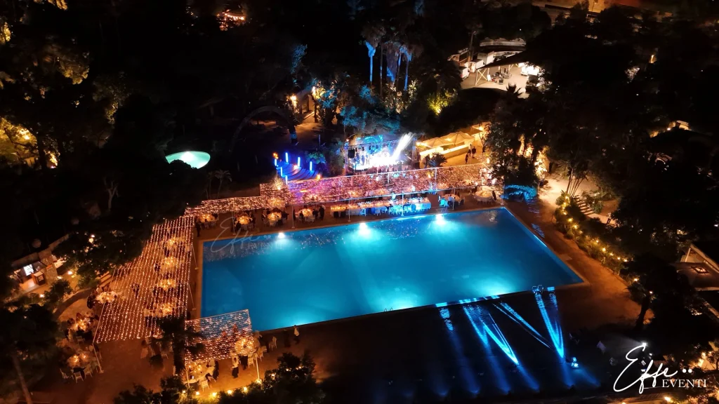 Matrimonio al Negombo di Ischia con allestimento total white, tavoli imperiali illuminati da milioni di luci e piscina scenografica.