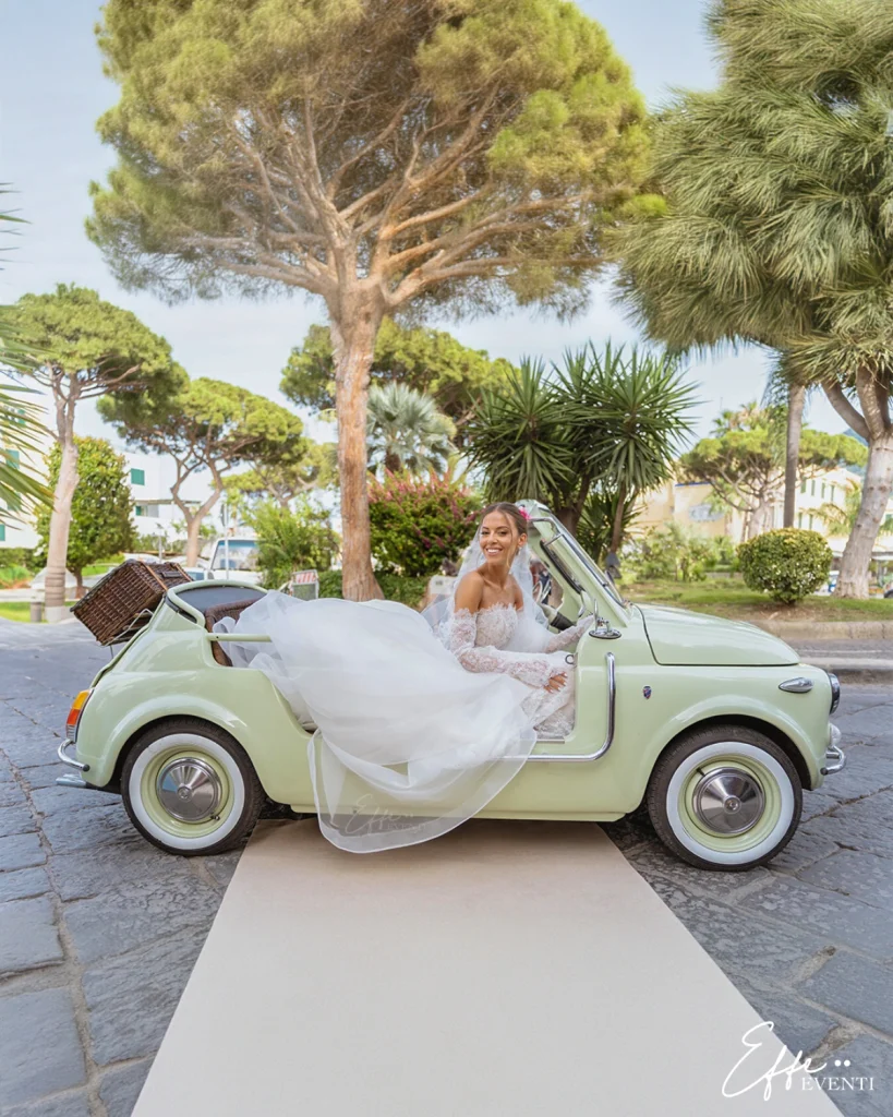 La sposa arriva all'ingresso della chiesa a bordo di una Fiat 500 d'epoca.